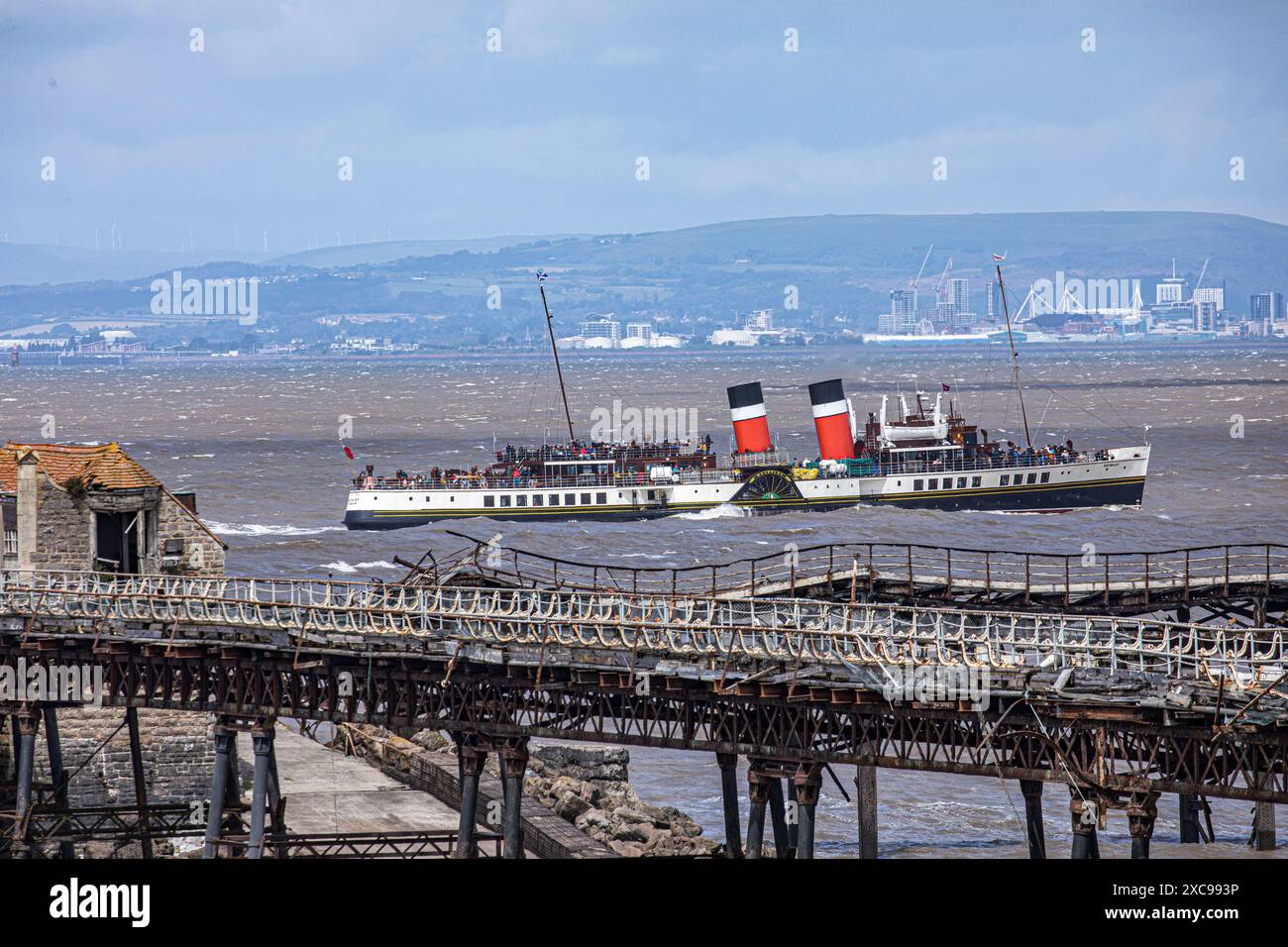 WESTON-SUPER-MARE, SOMERSET, Großbritannien, 15. Juni 2024, der letzte Raddampfer der Welt, Waverley, fährt durch den Bristol Channel am historischen Birnbeck Pier in Weston-super-Mare. Die Waverley ist in der National Historic Fleet als Schiff von herausragender nationaler Bedeutung registriert und wurde von National Historic Ships UK mit dem prestigeträchtigen Status des National Flagship of the Year 2024 ausgezeichnet. John Rose/Alamy Live News Stockfoto