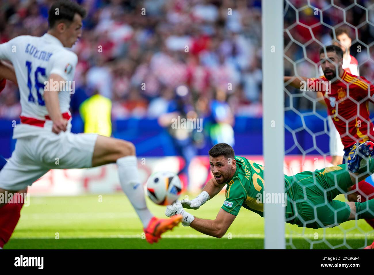 Spain's goalkeeper Unai Simon, bottom, looks on as Croatia's Ante Budimir misses a chance to score during a Group B match between Spain and Croatia at the Euro 2024 soccer tournament in Berlin, Germany, Saturday, June 15, 2024. (AP Photo/Ebrahim Noroozi) Stockfoto