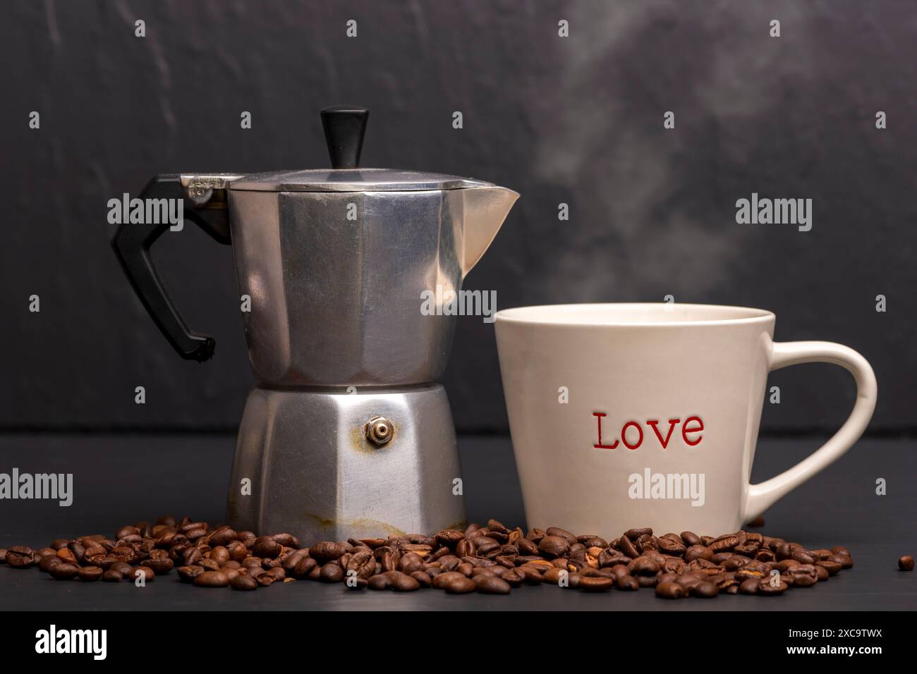 Kaffeetasse mit Liebe darauf. Kaffeekanne mit gerösteten Bohnen. Stockfoto