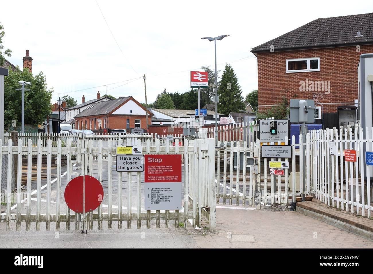 Fußgängerüberquerung Farnborough North Station Hampshire UK mit Gate- und Warnschildern - Eisenbahnsicherheit, unbemannte Kreuzung Stockfoto