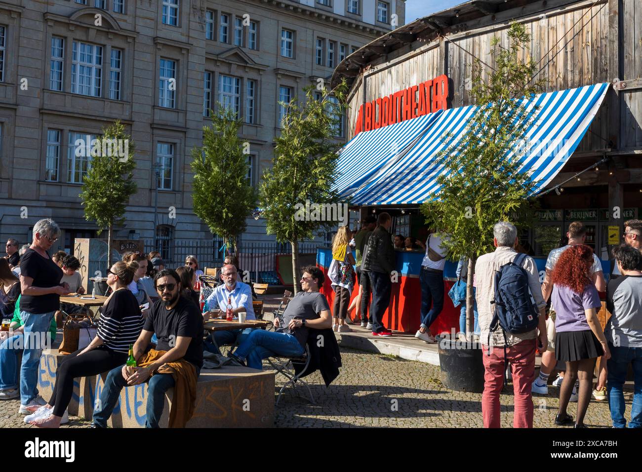 Berlin, Deutschland - 2. April 2024, Café in der Nähe des Monbijou-Theaters. Die Leute sitzen auf Bänken, schauen auf den Fluss, trinken Bier. Stockfoto