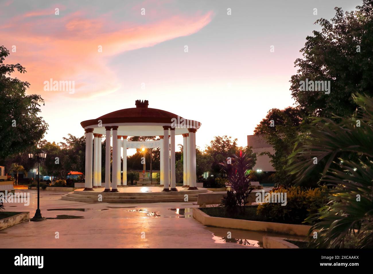 392 Parque Ricardo Cespedes Park in der Abenddämmerung mit einem überdachten zentralen Pavillon in Form einer runden Kolonnade - Monopteros oder Zyklostil -. Niquero-Kuba. Stockfoto