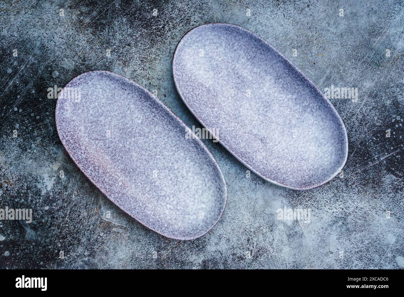 Paar leere blaue längliche Platten auf grauem Betonhintergrund. Draufsicht mit Kopierbereich Stockfoto