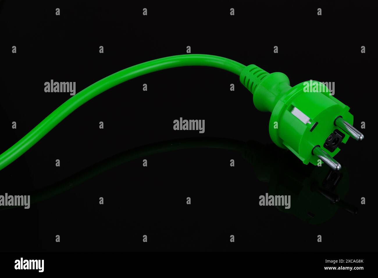 Grüner Netzstecker auf schwarzem Hintergrund Stockfoto