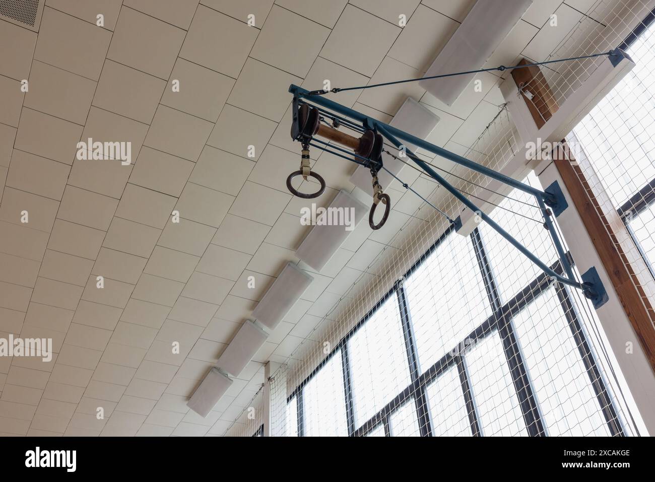 Turnringe hängen von der Decke in der modernen Sporthalle. Stockfoto