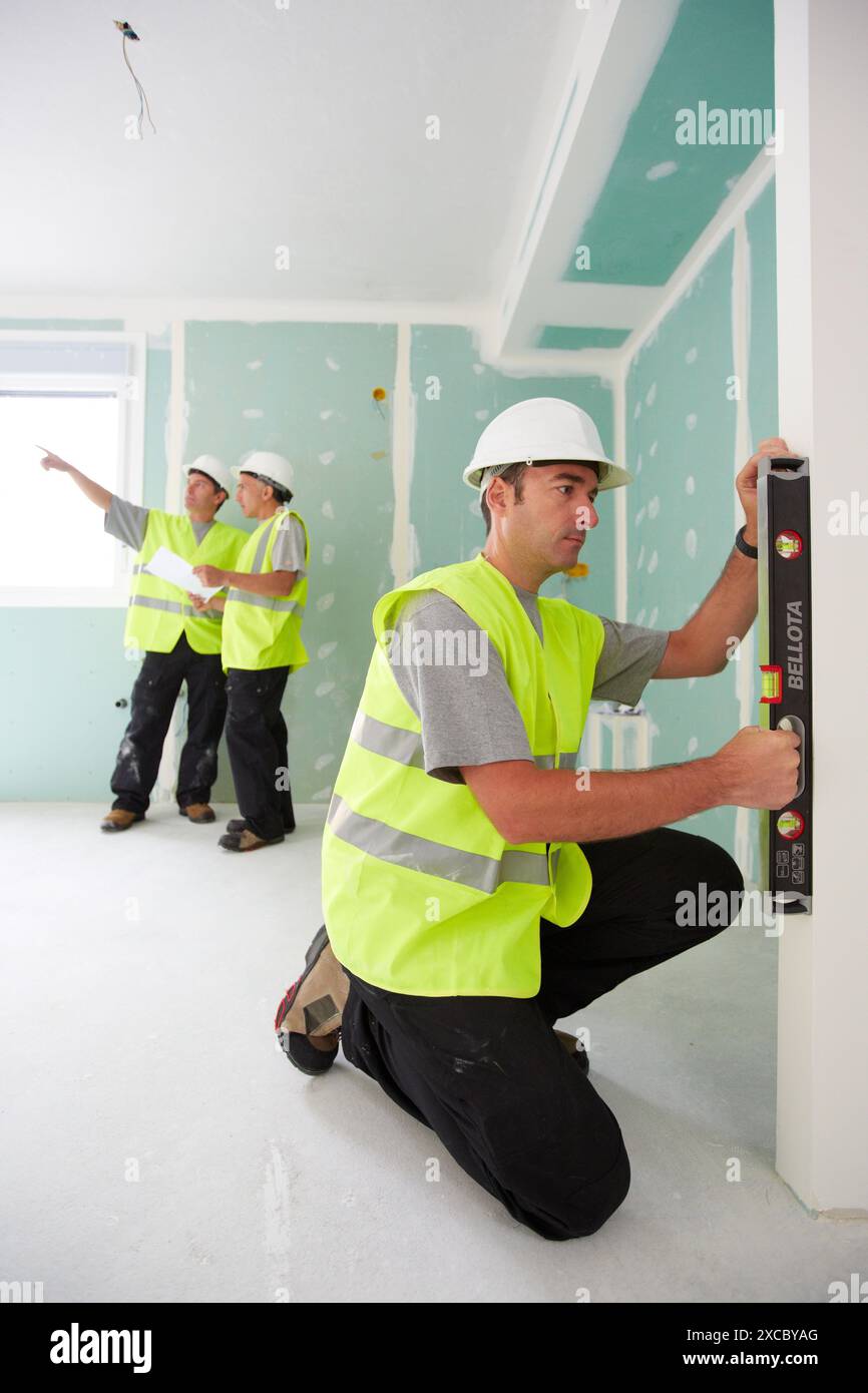 Arbeiter mit Schutzausrüstung, PSA, Leveling Gipskartonplatten, Wohnungsbau, Ebene, Baskisches Land, Spanien Stockfoto