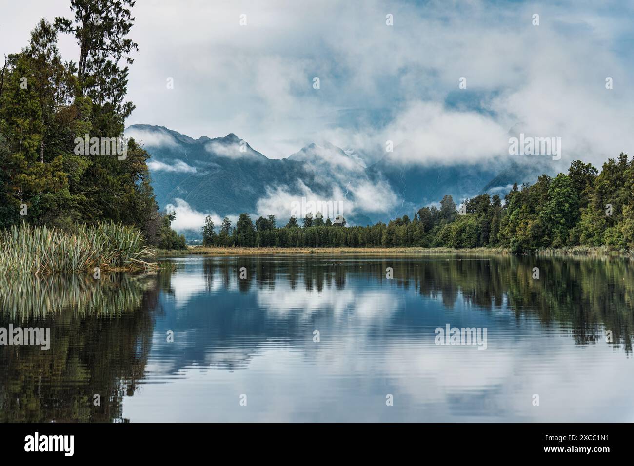 Landschaft des Lake Matheson Gletschersees mit Gebirgszügen und nebeliger Reflexion in Südwestland, Neuseeland Stockfoto