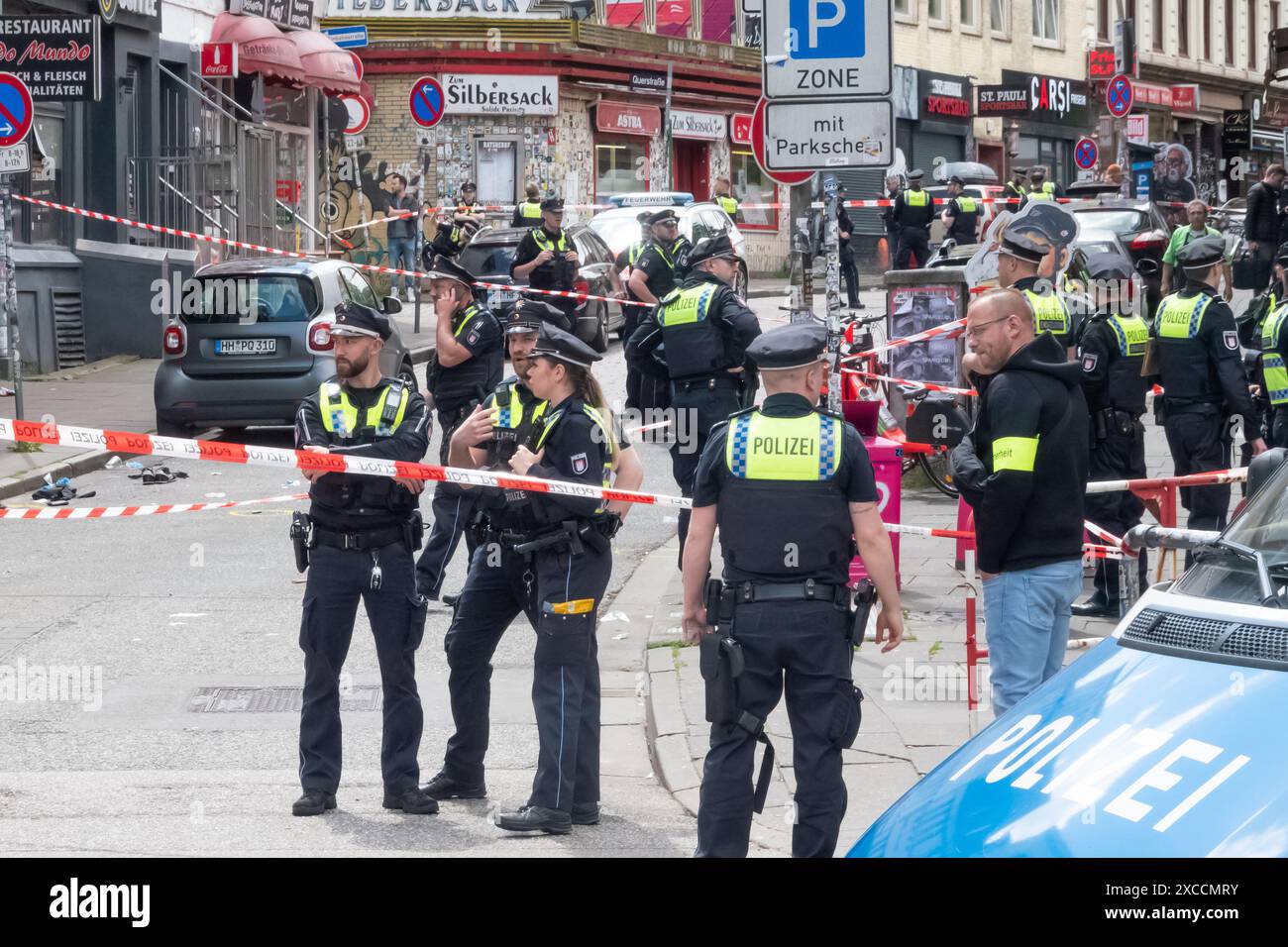 Hamburg, Deutschland. Juni 2024. Polizisten stehen am Tatort. Die Polizei hat einen Mann erschossen, der mit einer Spitzhacke und einem Molotow-Cocktail bewaffnet ist, in der Nähe der Reeperbahn in Hamburg-St. Pauli. Er wurde ins Bein geschlagen und wird medizinisch behandelt, sagte ein Polizeisprecher am Sonntag. Quelle: Bodo Marks/dpa/Alamy Live News Stockfoto