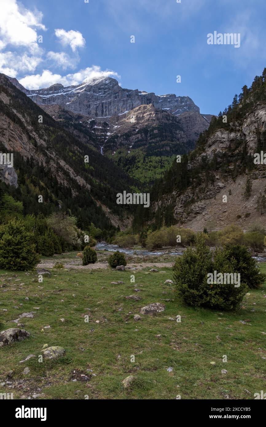 Landschaft mit grünem Tal, felsigen Hängen und einem Fluss unter blauem Himmel. Natur- und Reisekonzept Stockfoto