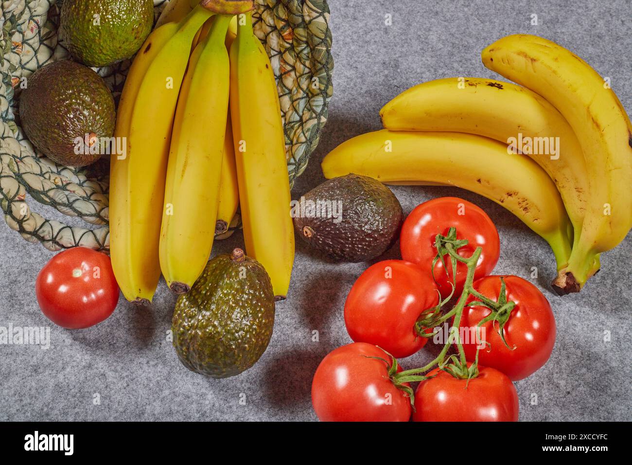 Bio-kaliumreiche Lebensmittel, Avocados, Bananen und Tomaten. Gesunde Sommerkost in einem Leinenkorb!!! Stockfoto