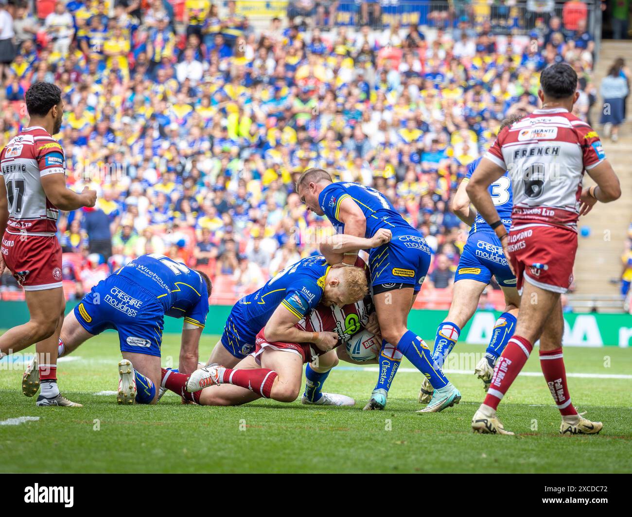Das Finale Des Betfred Challenge Cups 2024. Joe Bullock und Josh Drinkwater machen einen Tackle auf Liam Farrell Stockfoto