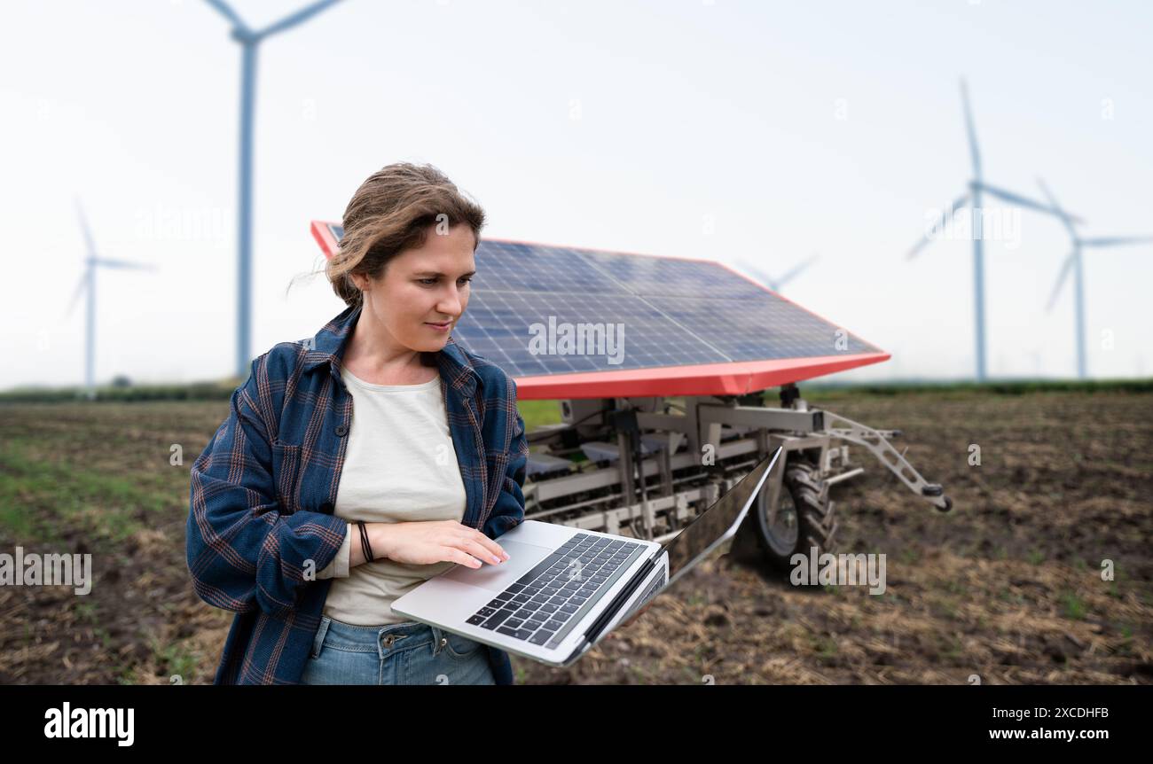 Der Landwirt steuert autonome Landmaschinen, die mit Solarenergie betrieben werden. Stockfoto