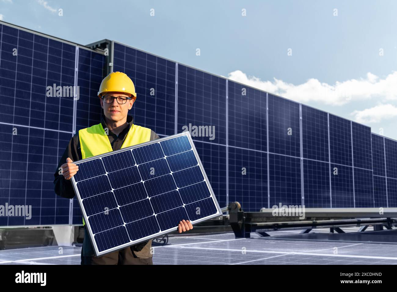 Arbeiter mit Sonnenkollektor auf einem Hintergrund der Solarstromanlage. Stockfoto