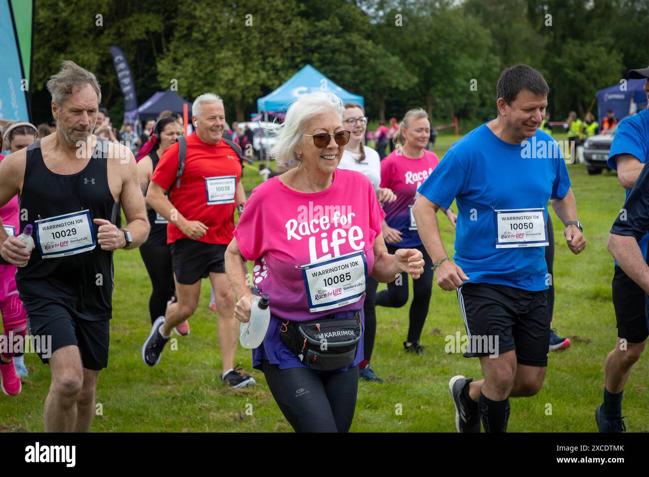 Warrington, Cheshire, Großbritannien. Juni 2024. Das jährlich stattfindende 10K-Rennen um das Leben zur Unterstützung von Cancer Research UK fand im Victoria Park, Warrington, statt. Das Rennen beginnt. Quelle: John Hopkins/Alamy Live News Stockfoto