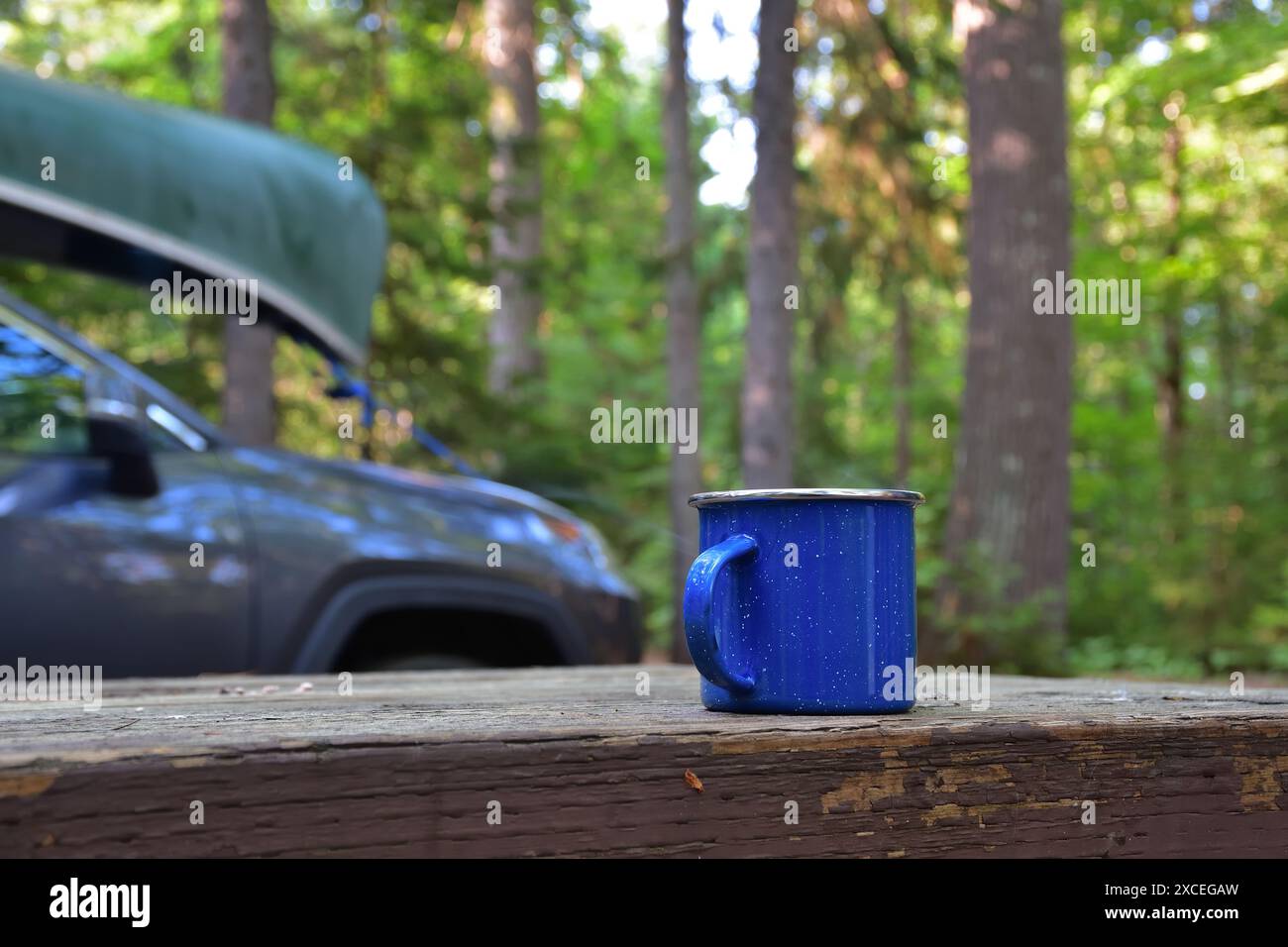 Blaue Emanel Kaffeetasse in der Natur. Vormittagsvorbereitung für den Tag des Kanufahrens. Entspannen Sie sich kurz vor dem aktiven Tag Stockfoto