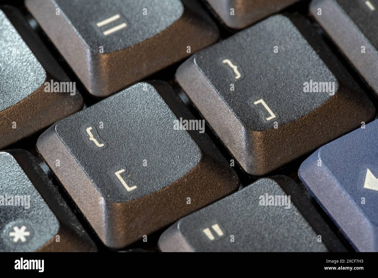 Geschweifte Klammern und eckige Klammern, Klammern-Symboltasten auf einer schwarzen Computertastatur, Objektmakro, extreme Nahaufnahme. Programmiersprachen für Computer ge Stockfoto