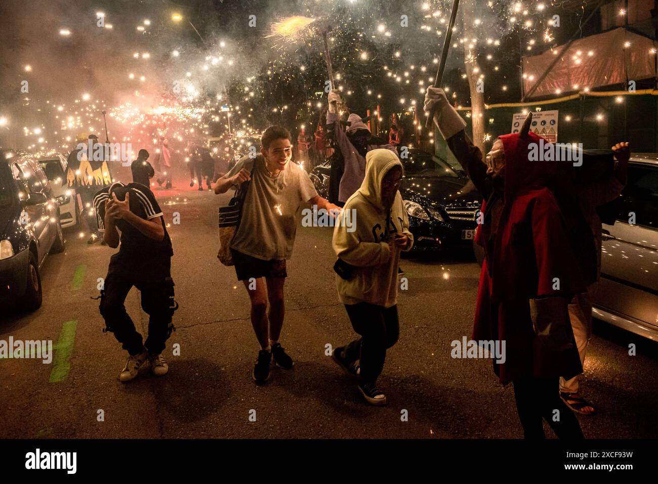 16. Juni 2024, Barcelona, Spanien: Während eines Korrefoc anlässlich des Stadtfestes La Guineueta in Barcelona reagieren die Enthüllenden, als Teufel gekleideten Menschen, die pyrotechnische Explosionen machen. Correfocs sind eine alte katalanische Tradition, in der sich die Menschen als Teufel kleiden und Feuerwerkskörper und Fackeln anfeuern. Bild: Jordi Boixareu/Alamy Live News. Stockfoto