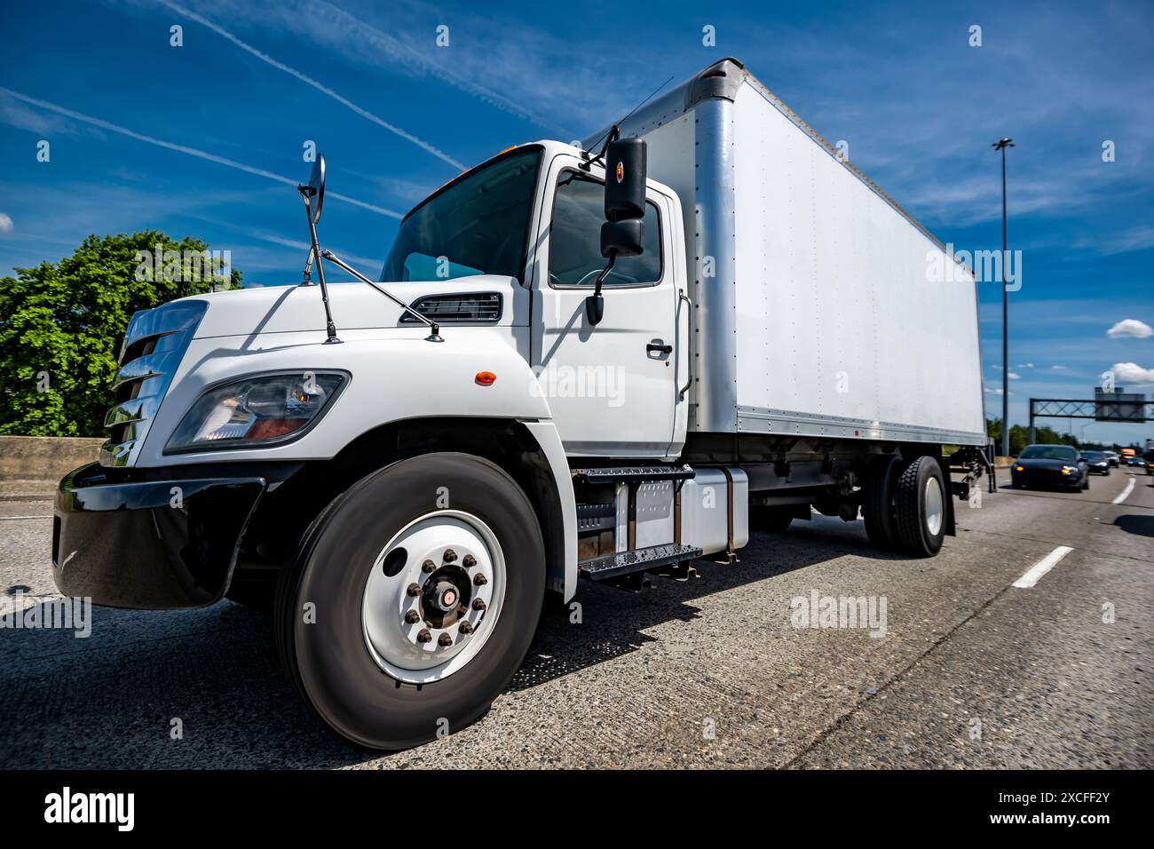 Industrietransportwagen mit weißem Tagfahrerhaus und langem Kastenanhänger für örtliche Fracht, die gewerbliche Fracht auf breiter Strecke transportieren Stockfoto