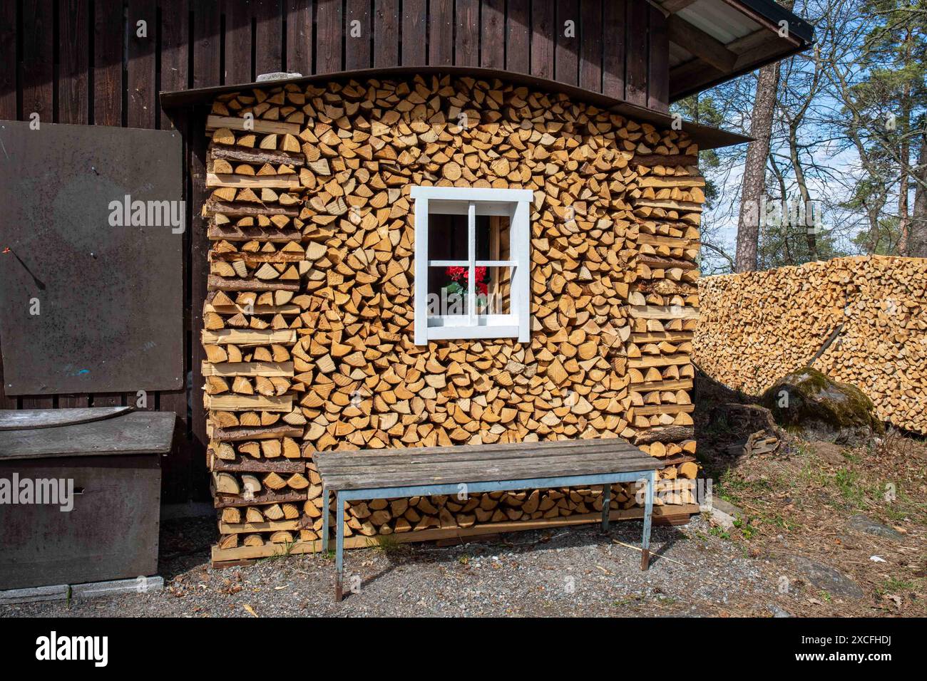 Sauber gestapeltes Brennholz, das einer Hauswand mit Fenster im Stadtteil Ruissalo in Turku, Finnland, ähnelt Stockfoto