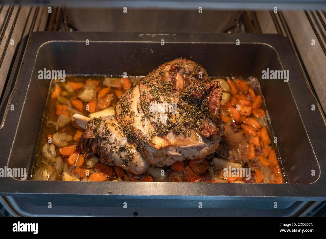 Frisch geröstetes Lammbraten mit Kräutern und Gemüse im Auflauf im Ofen, Bayern, Deutschland Stockfoto