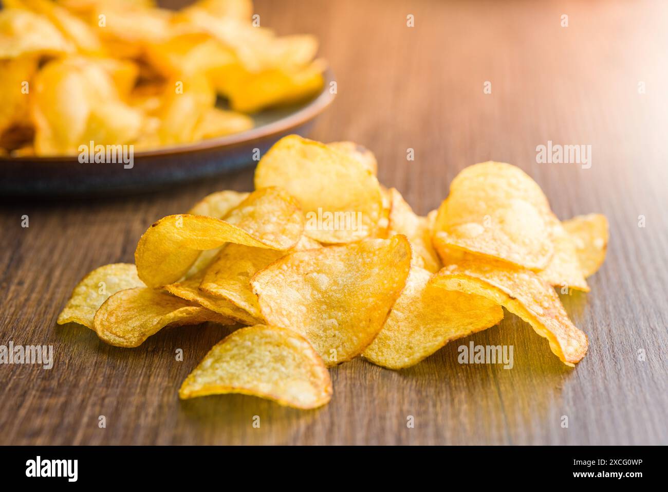 Knusprige Kartoffelchips auf einem Holztisch. Stockfoto