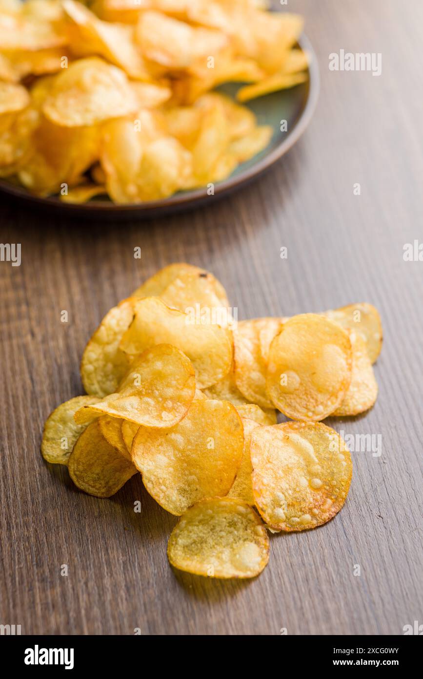 Knusprige Kartoffelchips auf einem Holztisch. Stockfoto