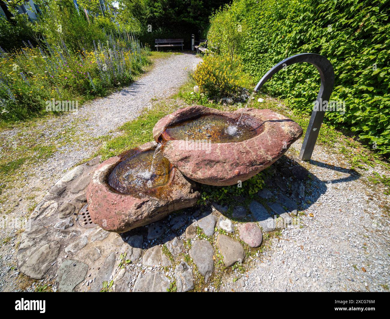 Mannedorf, Schweiz - 13. Juni 2024: Ein kleiner Freiluftbrunnen mit Trinkwasser im Park in Mannedorf, Schweiz Stockfoto
