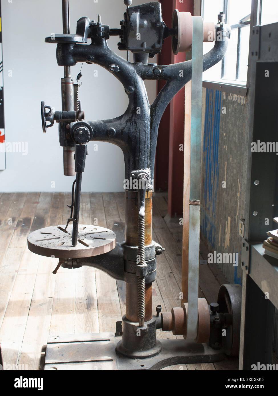 In einem Lager sitzt eine antikes Maschinenbau-Bohrmaschine. Stockfoto