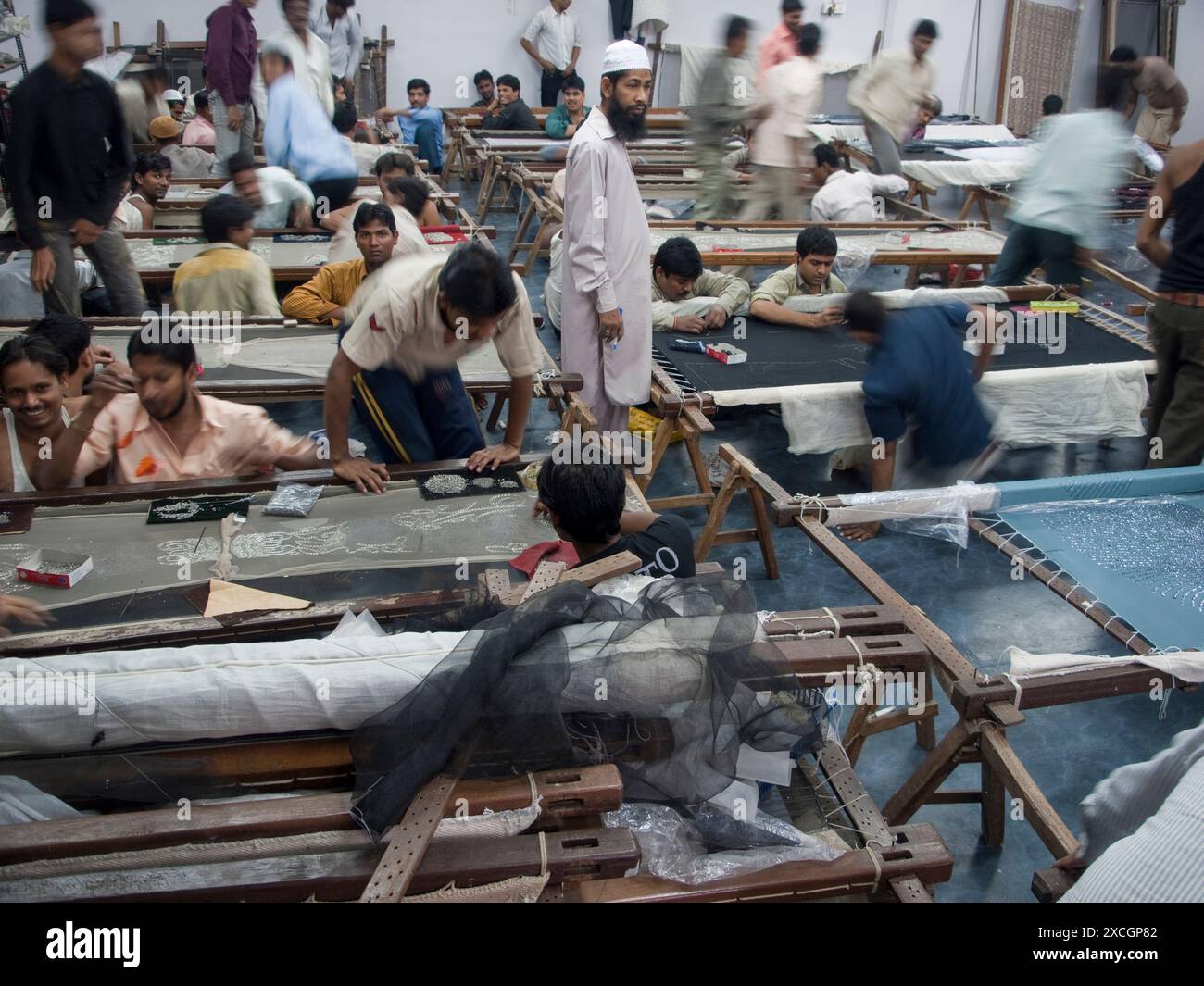 Arbeiter sortieren Verzierungen, Schnittmuster und Nähstickereien in der Werkstatt/im Büro eines indischen Unternehmens, das Stickarbeiten für die Modebranche herstellt, die verkauft wird Stockfoto