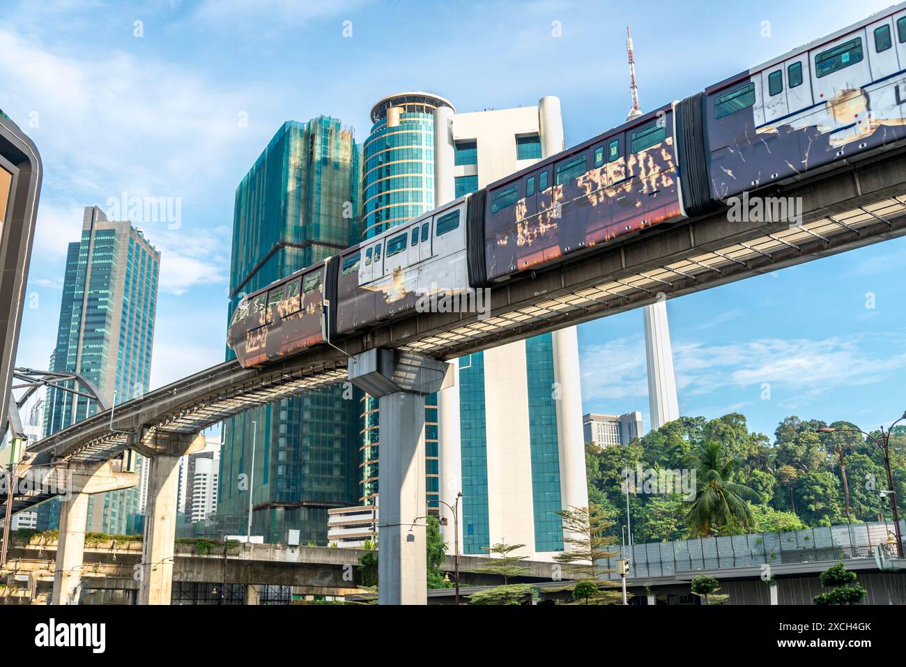 Ein modernes, effizientes, integriertes Verkehrsnetz, das über hohe Stützpfeiler aus Beton verläuft und sich sanft über die Skyline der Stadt schlängelt und viele miteinander verbindet Stockfoto