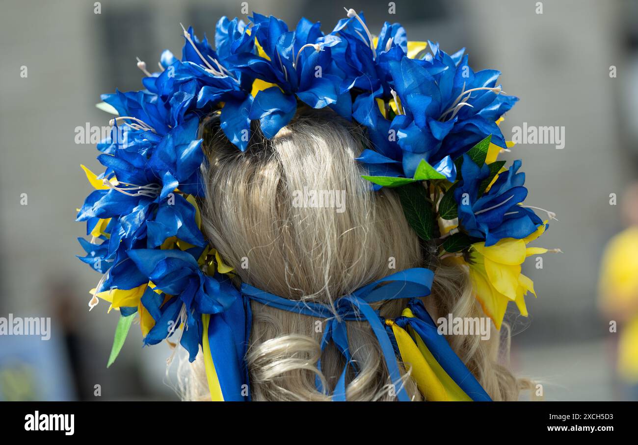 München, Deutschland. Juni 2024. Eine Frau, die einen Haarkranz in den Farben der Ukraine trägt, nimmt an einer Kundgebung auf dem Wittelsbacherplatz Teil. Insgesamt 77 ukrainische Stadien werden teilweise zerstört oder ruiniert. Quelle: Sven Hoppe/dpa/Alamy Live News Stockfoto