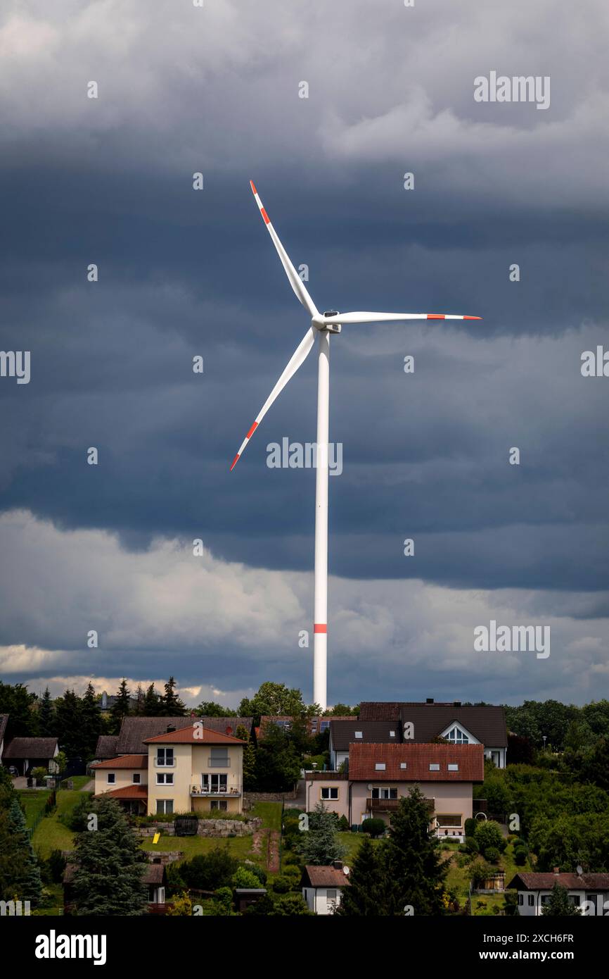 Bilderserie 16.06.2024 Windkraftanlagen im ländlichen Raum ein Windrad hinter einer Neubausiedlung mit dramatischen Wolken Markt Taschendorf, Steigerwald Bayern Deutschland *** Fotoserie 16 06 2024 Windkraftanlagen im ländlichen Raum Eine Windkraftanlage hinter einem neuen Wohngut mit dramatischen Wolken Markt Taschendorf, Steigerwald Bayern Deutschland Stockfoto