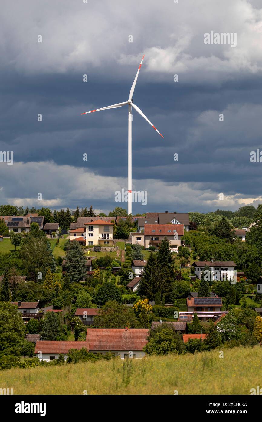 Bilderserie 16.06.2024 Windkraftanlagen im ländlichen Raum ein Windrad hinter einer Neubausiedlung mit dramatischen Wolken Markt Taschendorf, Steigerwald Bayern Deutschland *** Fotoserie 16 06 2024 Windkraftanlagen im ländlichen Raum Eine Windkraftanlage hinter einem neuen Wohngut mit dramatischen Wolken Markt Taschendorf, Steigerwald Bayern Deutschland Stockfoto