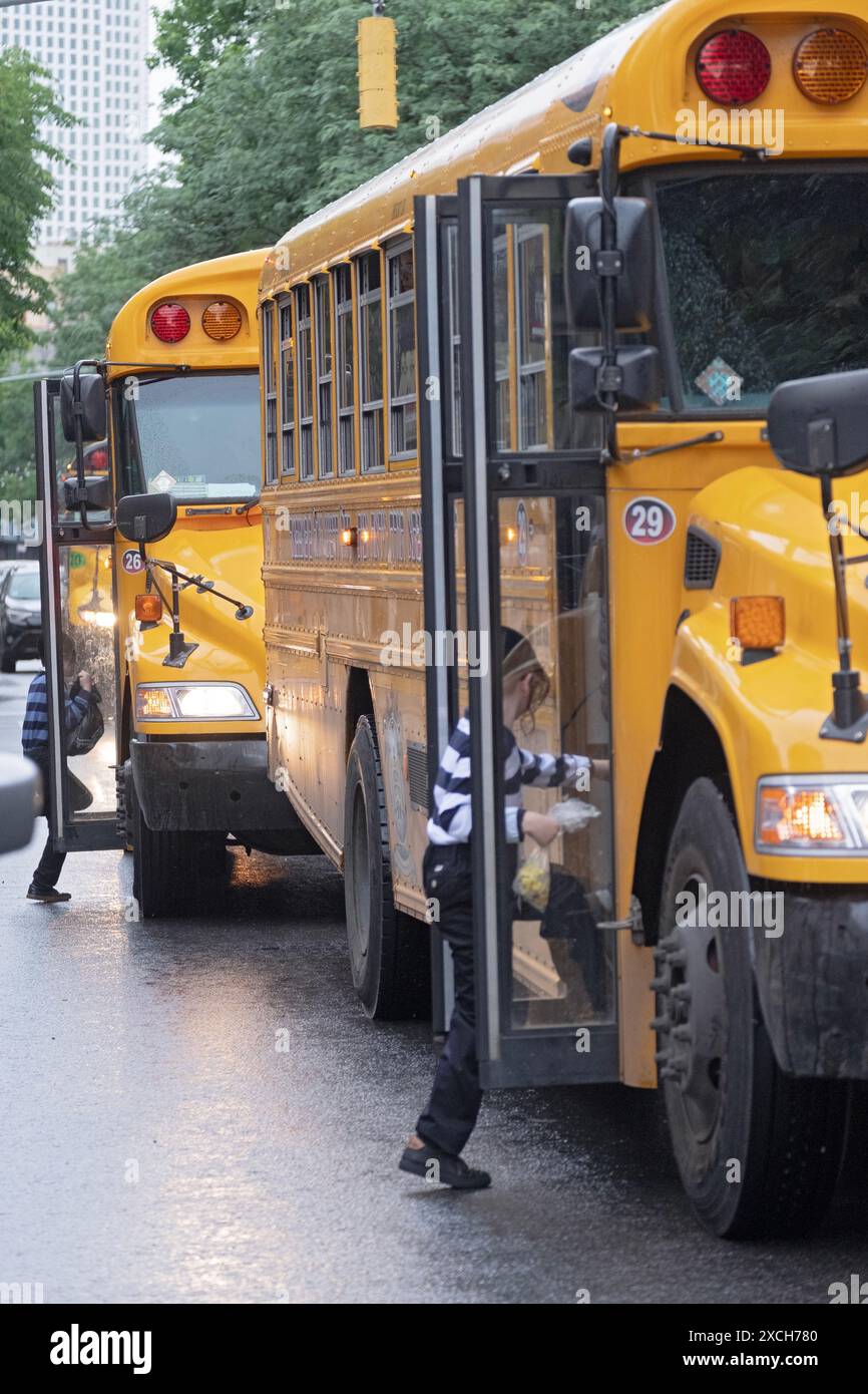 An einem nassen Morgen steigen 2 ultraorthodoxe jüdische Jungen in einen Bus zur Schule. Auf der Lee Avenue in Williamsburg, Brooklyn, New York. Stockfoto