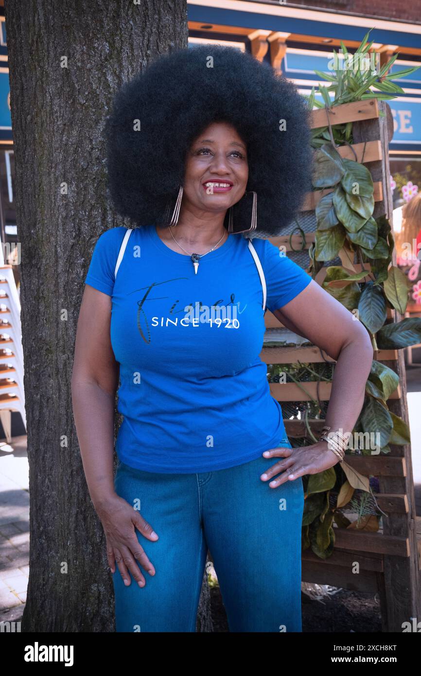 Eine attraktive Frau mittleren Alters mit einer tollen Afro-Frisur bei der jährlichen Juneteenth Parade in Peekskill, New York. Stockfoto