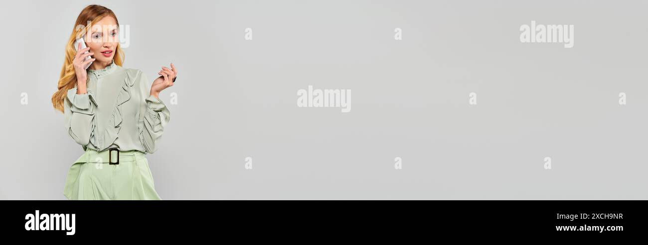 Eine Frau in einem grünen Rock, die sich an einem Telefongespräch beteiligt. Stockfoto