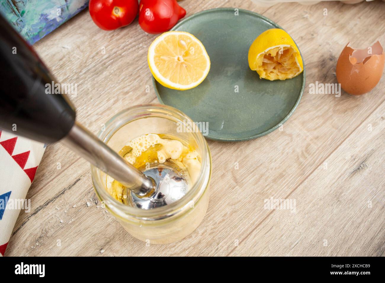 Zubereitung von Mayonnaise in einem Glasbehälter mit einem vertikalen Eintauchmixer, Nahaufnahme Stockfoto
