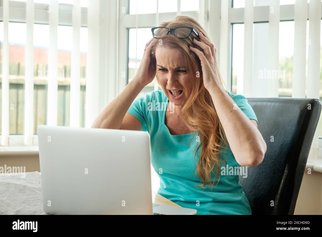 Ein wütender frustrierter externer Mitarbeiter zu Hause kämpfte mit der Technologie, während er versuchte zu arbeiten. Technologische Probleme und Frustrationen. Technische Wut Stockfoto