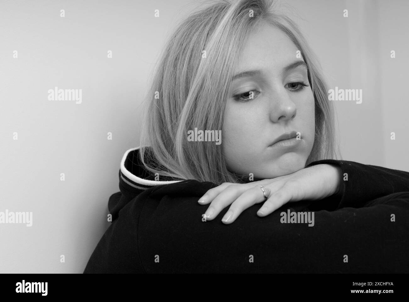 Deprimiertes kaukasisches Teenager-Mädchen. Ich schaue mit der Hand unter dem Kinn nach unten. USA Stockfoto