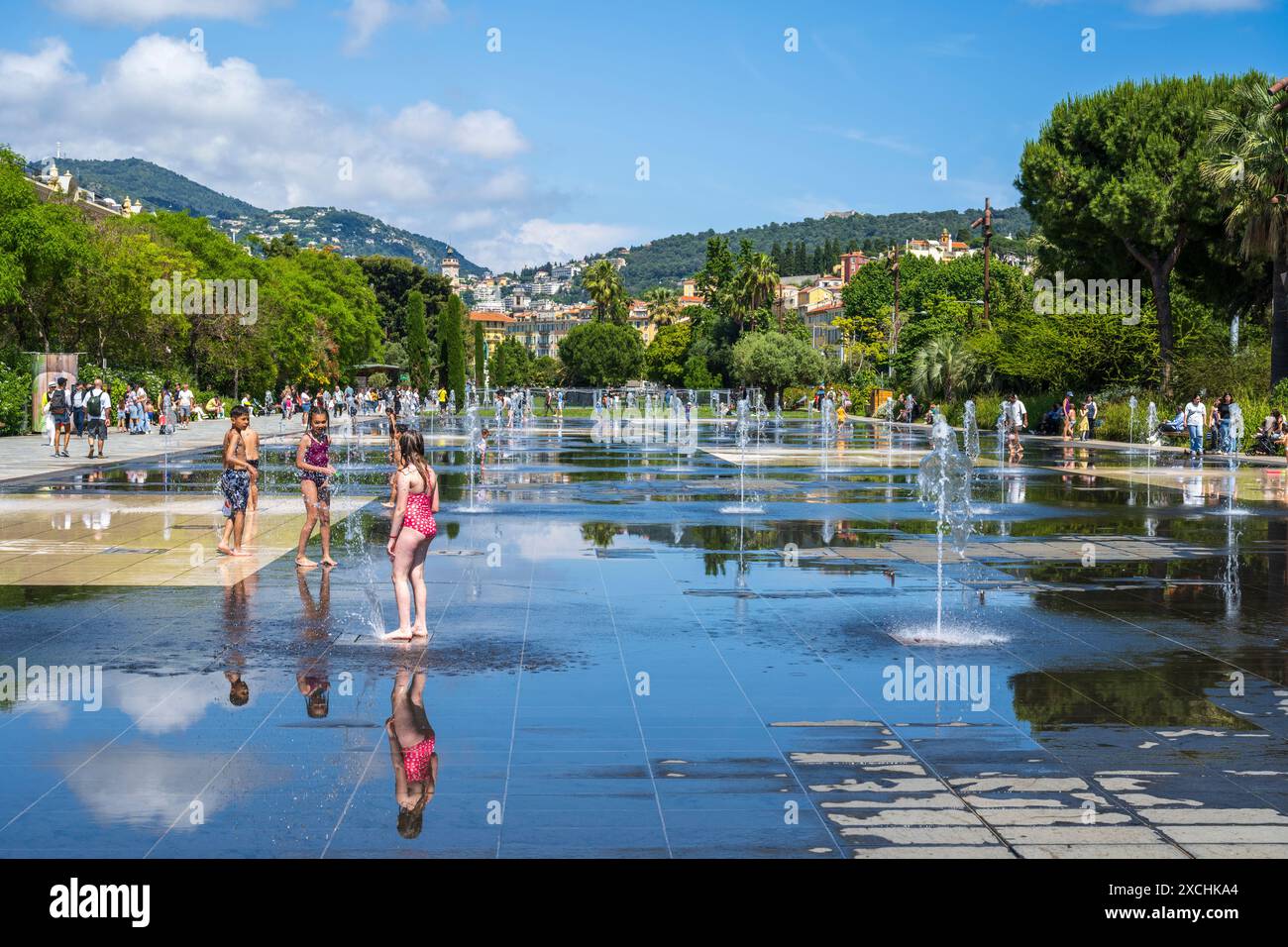 Spaß im Wasserstrahl Fontaine Miroir d’Eau auf der Promenade du Paillon in der Altstadt von Nizza, der französischen Riviera, der Côte d'Azur, der Provence, Frankreich Stockfoto