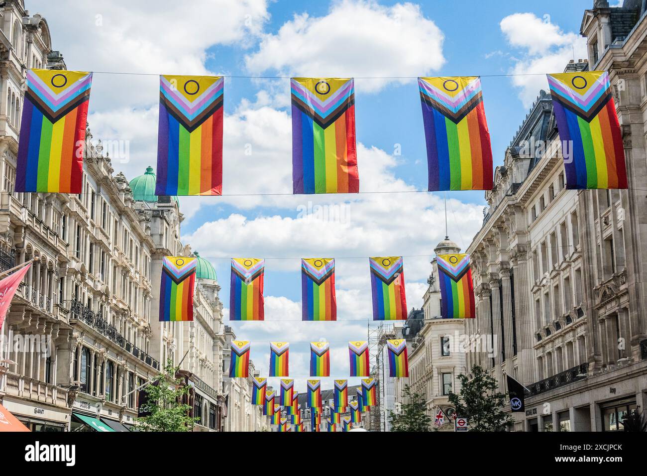 London, Großbritannien. Juni 2024. An einem sonnigen Tag auf der Regent Street gibt es Flaggen als Teil des Pride Month. Die neue Progress Pride Flag von Daniel Quasar integriert viele Pride Flags in eine, um mehr Wert auf „Inklusion und Progression“ zu legen. Es enthält jetzt Streifen, die die Erfahrungen von Menschen mit Farbe darstellen, sowie Streifen, die Menschen repräsentieren, die sich als Transgender, Gender non conforming (GNC) und/oder undefiniert identifizieren. Guy Bell/Alamy Live News Stockfoto