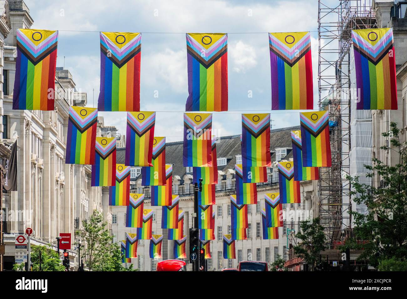 London, Großbritannien. Juni 2024. An einem sonnigen Tag auf der Regent Street gibt es Flaggen als Teil des Pride Month. Die neue Progress Pride Flag von Daniel Quasar integriert viele Pride Flags in eine, um mehr Wert auf „Inklusion und Progression“ zu legen. Es enthält jetzt Streifen, die die Erfahrungen von Menschen mit Farbe darstellen, sowie Streifen, die Menschen repräsentieren, die sich als Transgender, Gender non conforming (GNC) und/oder undefiniert identifizieren. Guy Bell/Alamy Live News Stockfoto