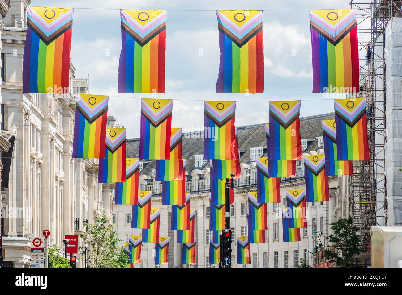 London, Großbritannien. Juni 2024. An einem sonnigen Tag auf der Regent Street gibt es Flaggen als Teil des Pride Month. Die neue Progress Pride Flag von Daniel Quasar integriert viele Pride Flags in eine, um mehr Wert auf „Inklusion und Progression“ zu legen. Es enthält jetzt Streifen, die die Erfahrungen von Menschen mit Farbe darstellen, sowie Streifen, die Menschen repräsentieren, die sich als Transgender, Gender non conforming (GNC) und/oder undefiniert identifizieren. Guy Bell/Alamy Live News Stockfoto