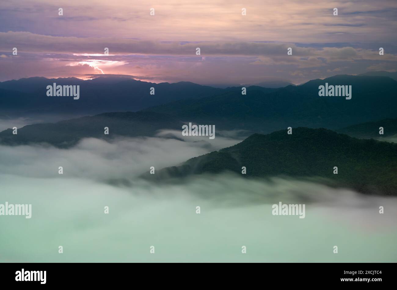 Nachts bewegt sich das Wolkenmeer schnell, und der Blitz ist dicht und schnell. Blick auf die Berge rund um das Emerald Reservoir. Bezirk Xindian, Tai Stockfoto