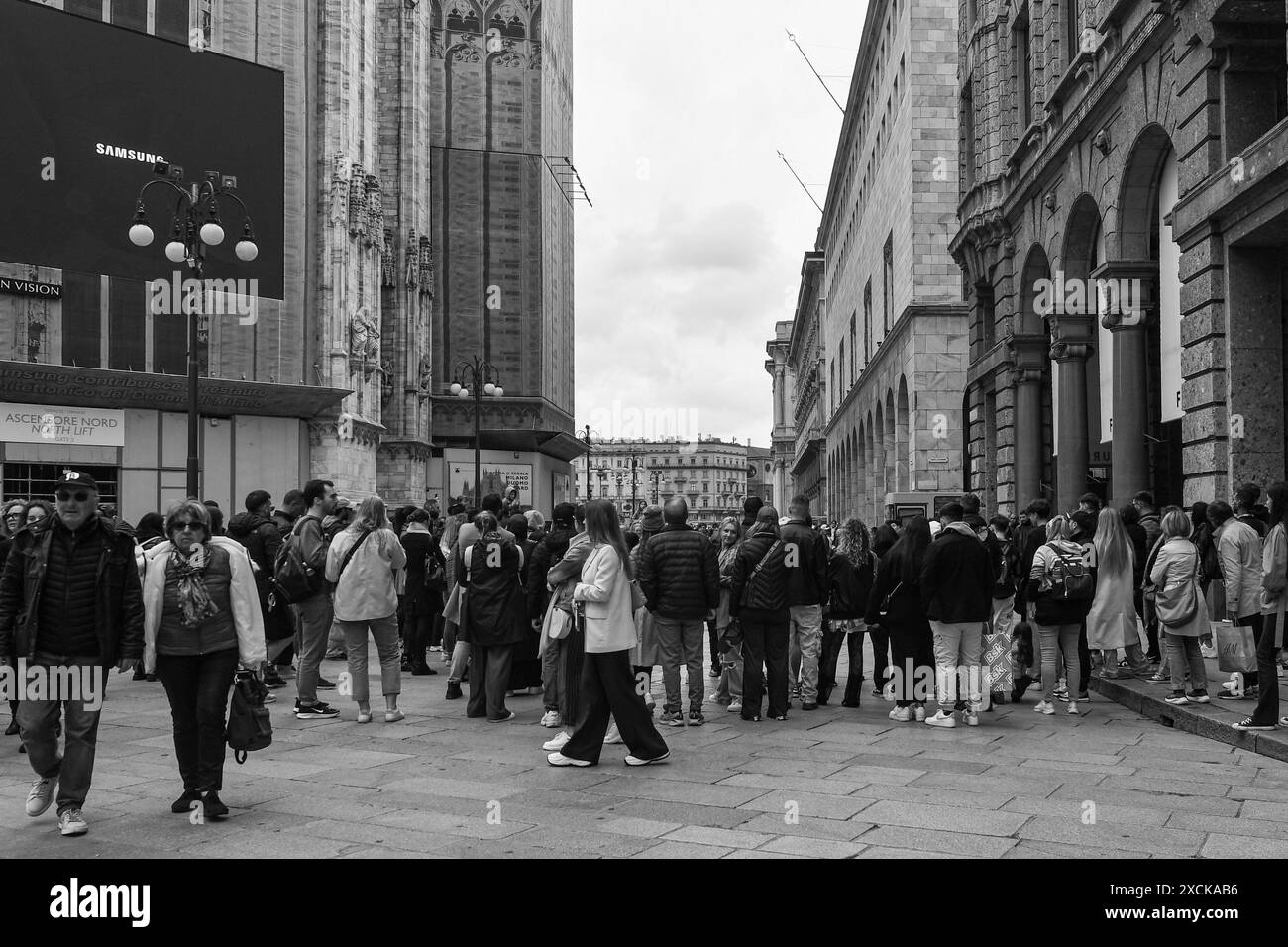 Menschenmenge, die eine Straßenaufführung auf der Piazza del Duomo auf der Rückseite der Mailänder Kathedrale mit dem Samsung Maxi-Bildschirm in Mailand, Italien, ansieht Stockfoto