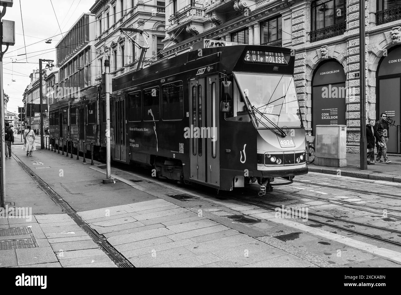 Schwarzweißfoto. Die Straßenbahn fährt in die Via Broletto, im Stadtzentrum von Mailand, Lombardei, Italien Stockfoto