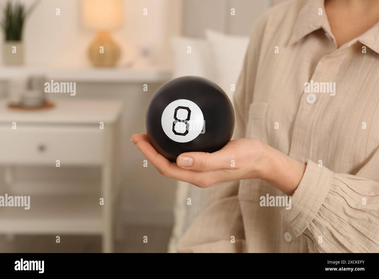 Frau, die einen magischen Acht Ball im Haus hält, Nahaufnahme Stockfoto