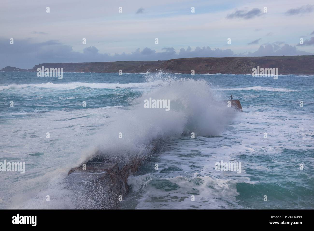 Wellen stürzen über Sennen Cove's Jetty, stürmische Meere in Cornwall Stockfoto