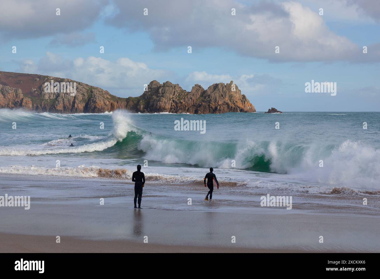 Surfer am Porthcurno Beach; Logan's Rock, Cornwall Stockfoto