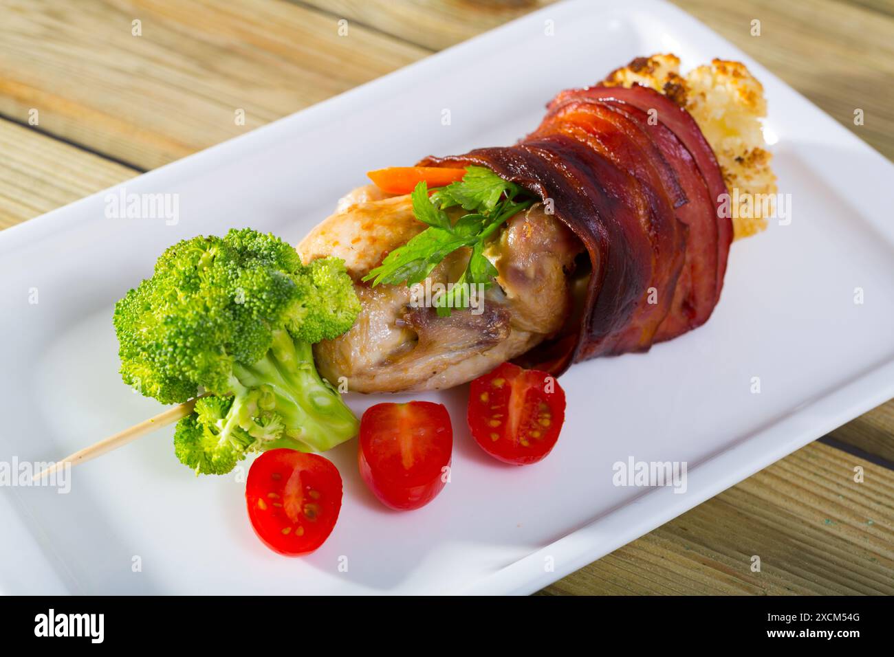 Gegrillte Wachteln im Jamon auf Spieß mit Gemüse Stockfoto